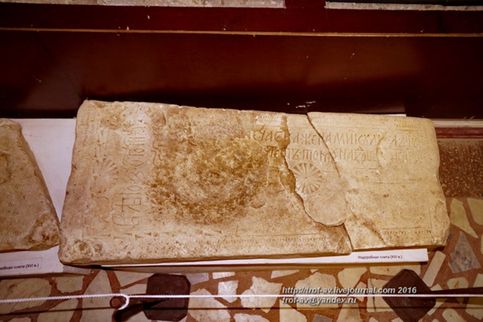 Средневековая (XVI век) надгробная плита с вилообразным крестом и орнаментом волчий зуб, с более поздним текстом (который вдоль). Краеведческий музей Волоколамска